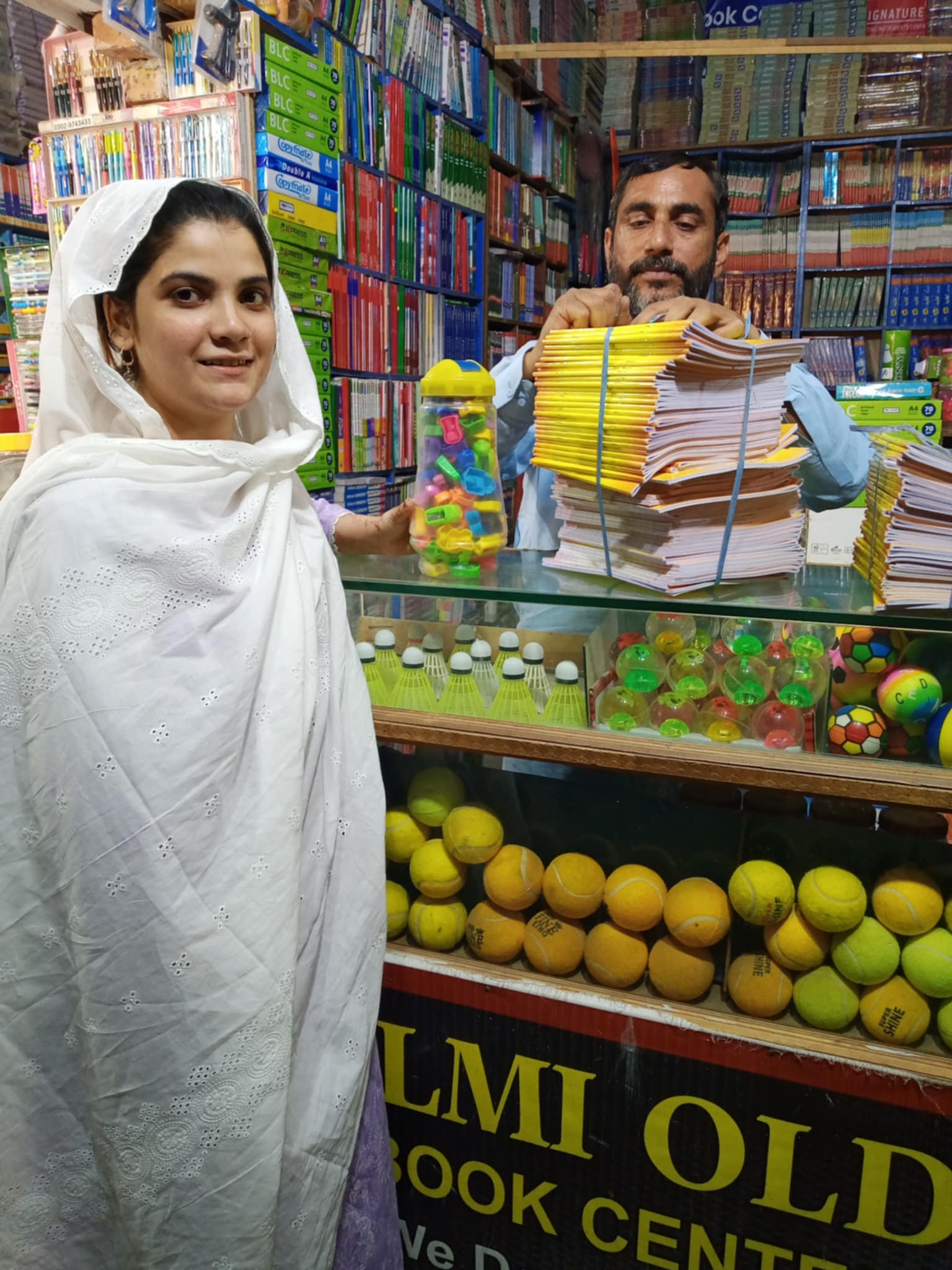 A volunteer collecting notebooks and school supplies at a bookshop.